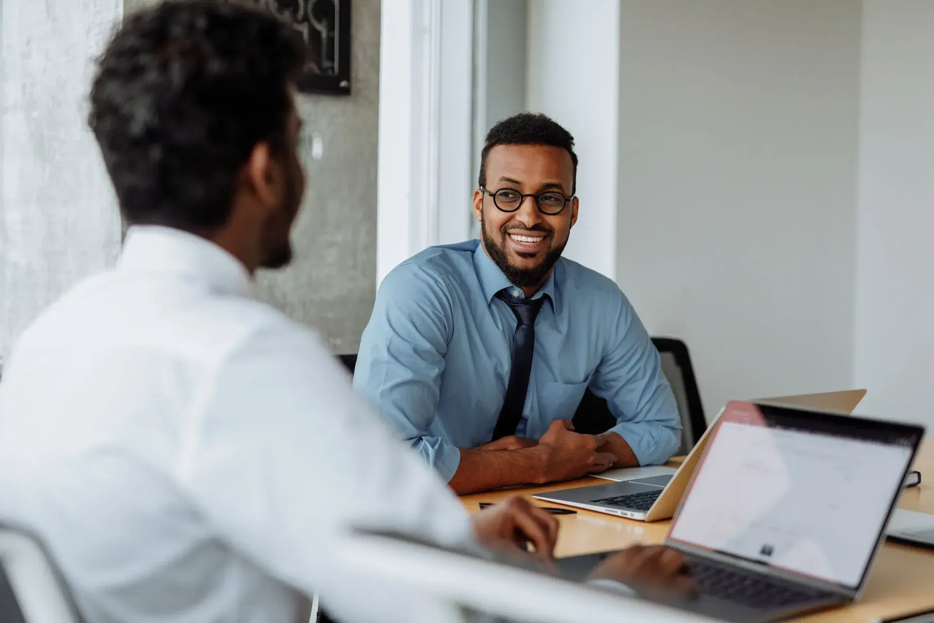 Colegas conversando no escritório de pequena empresa com Bradesco Saúde Efetivo Plus