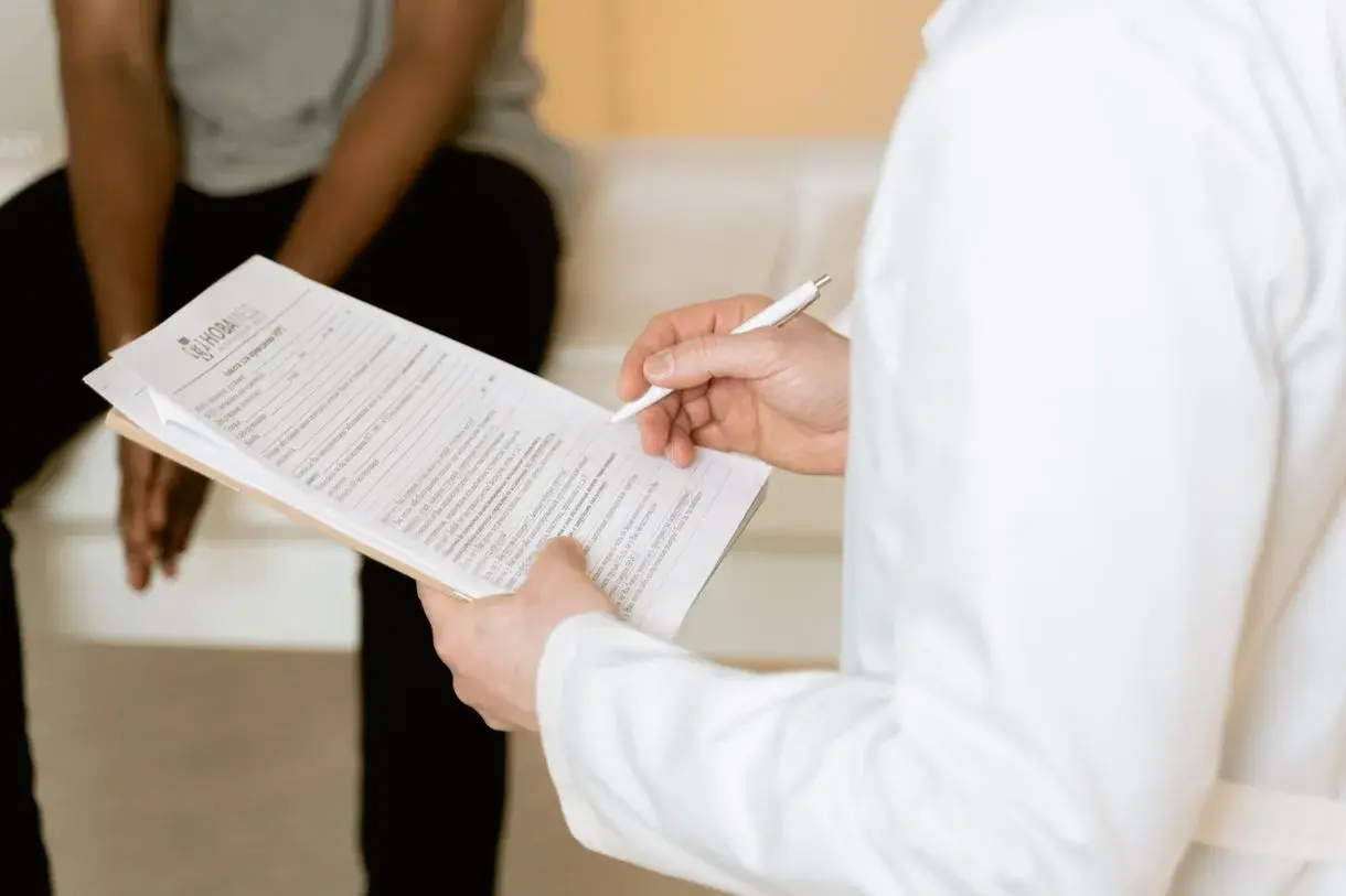 Médica preenchendo ficha durante consulta de paciente com Bradesco Saúde Nacional