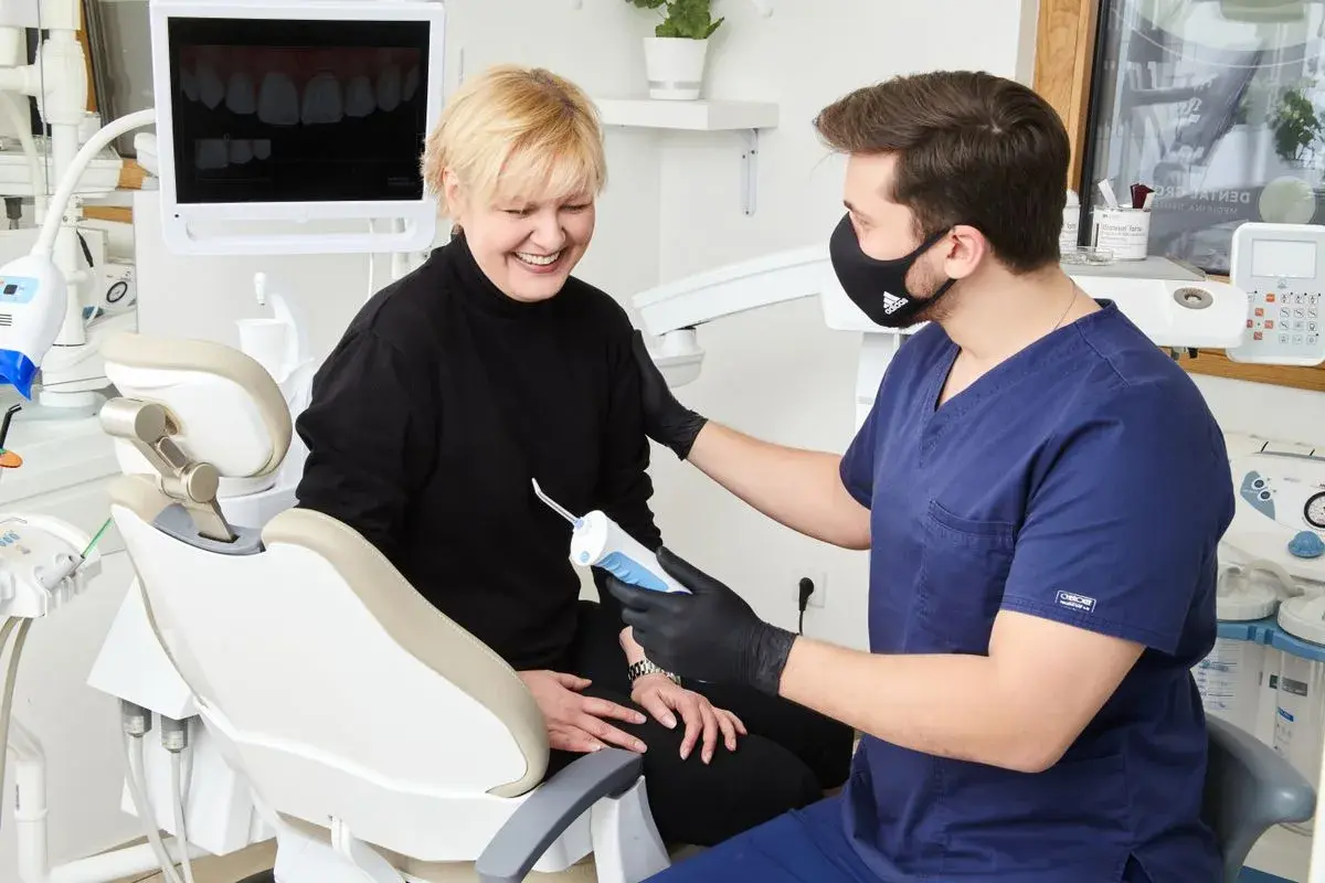 Dentista conversando com paciente sorridente em consultório da rede Bradesco Dental