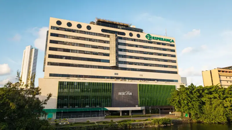 Fachada clara com letreiro verde do Hospital Esperança, no Recife