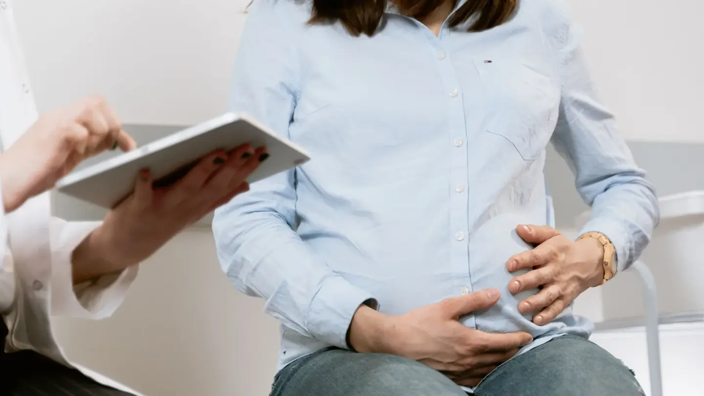 Gestante em consulta de pré-natal com a médica, que anota no tablet as informações do plano de saúde