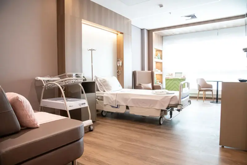 Quarto da maternidade da Casa de Saúde São José, com berço e sofá